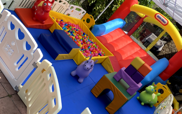 Colorful outdoor kids' play area with ball pit and inflatable slide.