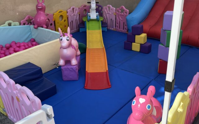 Colorful indoor playground with soft toys and slides for children.