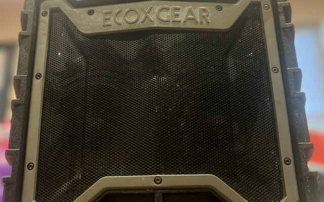 A black and gray rugged outdoor speaker with a protective casing.