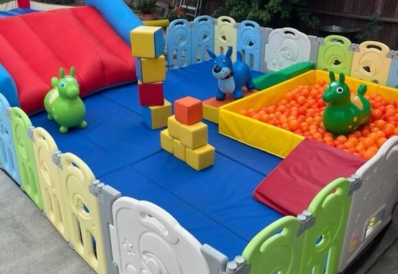Colorful inflatable play area with ball pit and bounce house for kids.