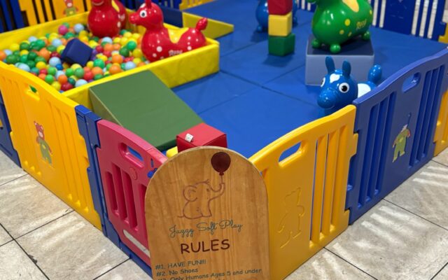 Colorful playpen filled with toys for toddlers.